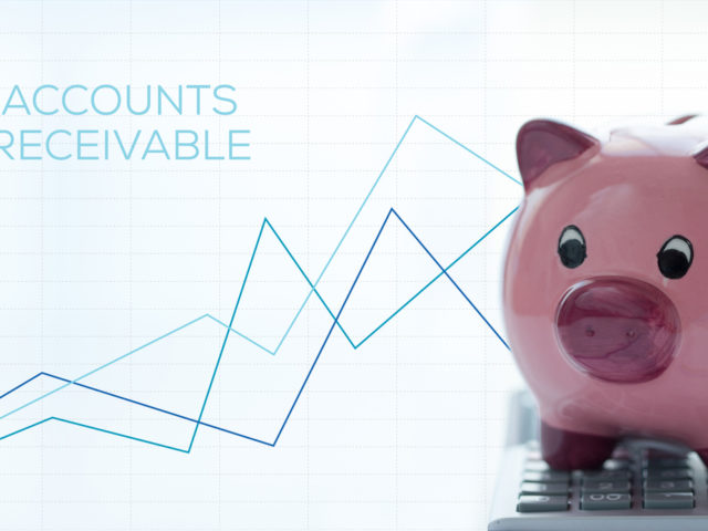 A piggy bank sits on a calculator in front of a graph that says accounts receivable