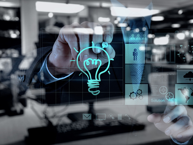 A man is drawing a light bulb on a glass screen