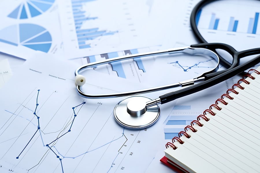 stethoscope and eyeglasses resting on medical charts and financial reports: Revenue Cycle Management