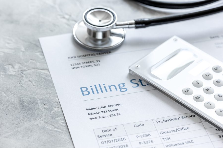 billing statement for for medical service in doctor's office on stone desk