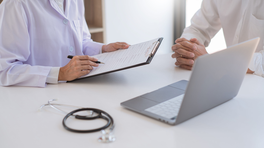 doctor in office discussing bills
